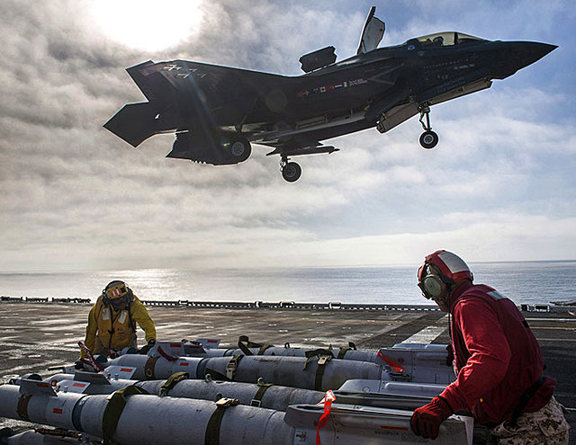 Sailors assigned to amphibious assault ship USS America (LHA 6) and F-35B Lightning II Marine Corps personnel prepared to equip the aircraft with 500-pound GBU-12 Paveway™ II Plus Laser Guided Bombs during F-35B flight test operations in the Pacific Ocean. (Image courtesy of the U.S. Navy)