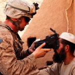 U.S. Marine from Fox Company, 2nd Battalion, 2nd Marine Regiment (2/2) scans an Afghan man’s retinas using a Biometric Enrollment and Screening Device (BESD) while conducting counter-insurgency operations in Helmand province, Afghanistan. (Image courtesy of U.S. Marine Corps)