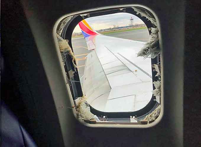 Oxygen masks and a blown out window are seen from inside a Southwest Airlines plane after an emergency landing at the Philadelphia airport, April 17, 2018. (Image courtesy of Marty Martinez, Twitter)