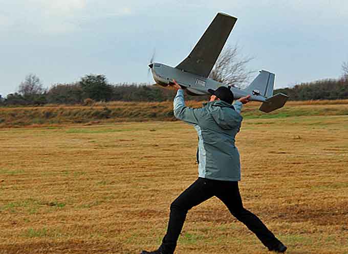 A Coast Guard representative launches the 'AeroVironment Puma' All-Environment drone during the Singing River Island payload evaluations. DHS and the Coast Guard can use this drone for multiple missions depending on the payload. (Courtesy of the U.S. Coast Guard)