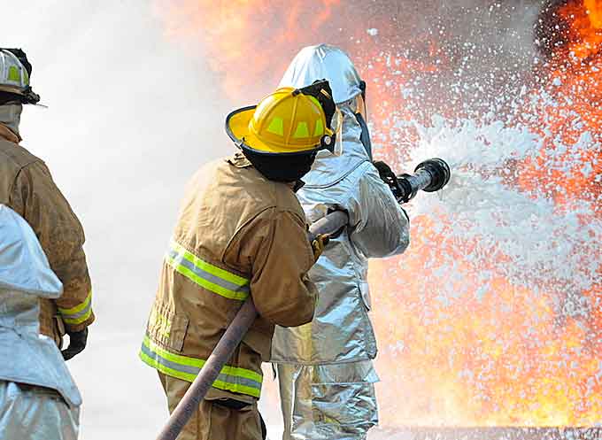 U.S. Air Force and New Jersey state fire protection specialists from the New Jersey Air National Guard’s 177th Fighter Wing battle a simulated aircraft fire with Aqueous Film Forming Foam at Military Sealift Command Training Center East in Freehold, N.J. (Courtesy of U.S. Air National Guard by Airman 1st Class Amber Powell)