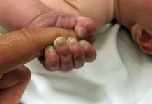 A 5-month-old infant with dirt under his fingernails after authorities say the baby survived hours being buried under sticks and debris in the woods on July 8, 2018. (Courtesy o f the Missoula County Sheriff's Office)