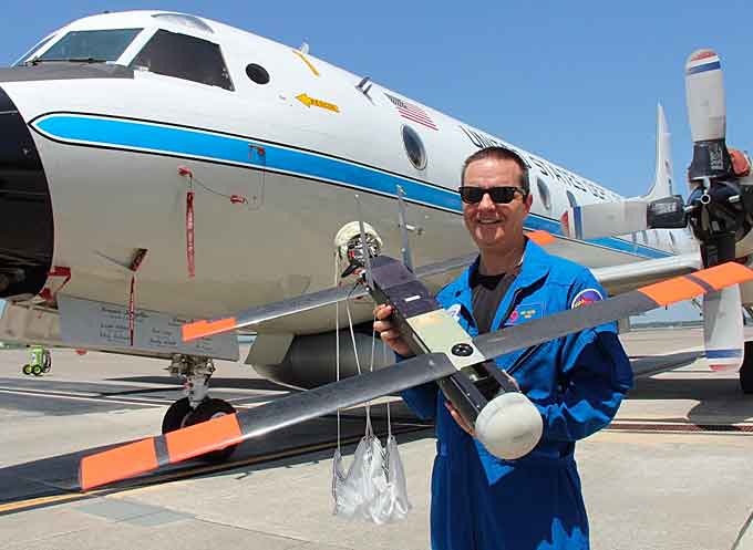 Dr. Joe Cione, hurricane researcher at NOAA’s Atlantic Oceanographic and Meteorological Laboratory and chief scientist of the Coyote® unmanned aircraft system program, holds the UAS in front of NOAA’s P-3 aircraft at MacDill Air Force Base in Tampa, Florida. (Courtesy of the National Oceanic and Atmospheric Administration)