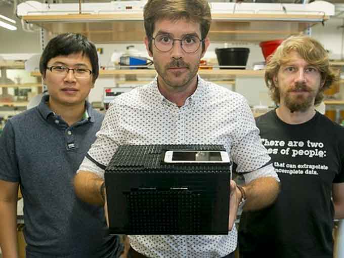 Xiaolong Sun, (left to right), a post-doctoral fellow in the chemistry department, Pedro Metola, a clinical assistant professor in the natural sciences department, and Alexander Boulgakov, a graduate student in the molecular biosciences department, show their Lego box nerve gas detector at the University of Texas this week. (Courtesy of Jay Janner, American-Statesman and Twitter)