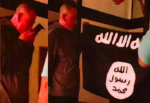 In this July 8, 2017 photo taken from an FBI video, Army Sgt. 1st Class Ikaika Kang holds an Islamic State group flag after allegedly pledging allegiance to the terror group at a house in Honolulu. (Courtesy of the U.S. Attorney’s Office in Hawaii and the FBI)