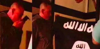 In this July 8, 2017 photo taken from an FBI video, Army Sgt. 1st Class Ikaika Kang holds an Islamic State group flag after allegedly pledging allegiance to the terror group at a house in Honolulu. (Courtesy of the U.S. Attorney’s Office in Hawaii and the FBI)