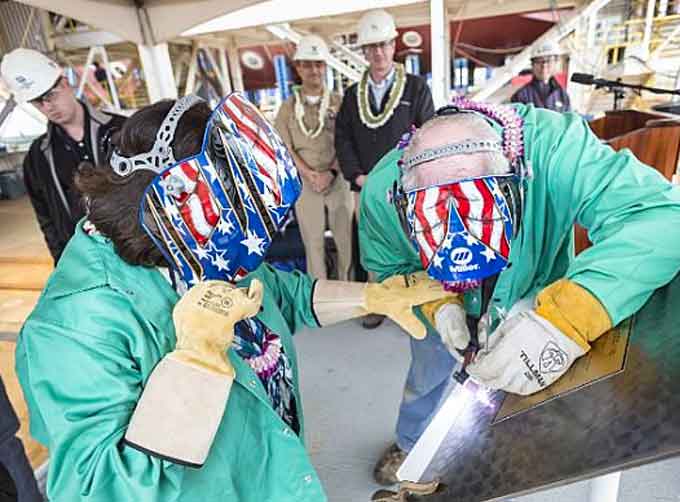Irene Hirano Inouye, left, and Frank Wood, a Bath Iron Works welder, authenticate the keel of the future guided-missile destroyer USS Daniel Inouye (DDG 118) at Bath Iron Works in Bath, Maine, May 14, 2018.