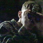 A Marine peers through the lens of the Squad Binocular Night Vision Goggles during new equipment training in December 2018 at Camp Lejeune, North Carolina (Courtesy of the US Marine Corps, by Joseph Neigh)