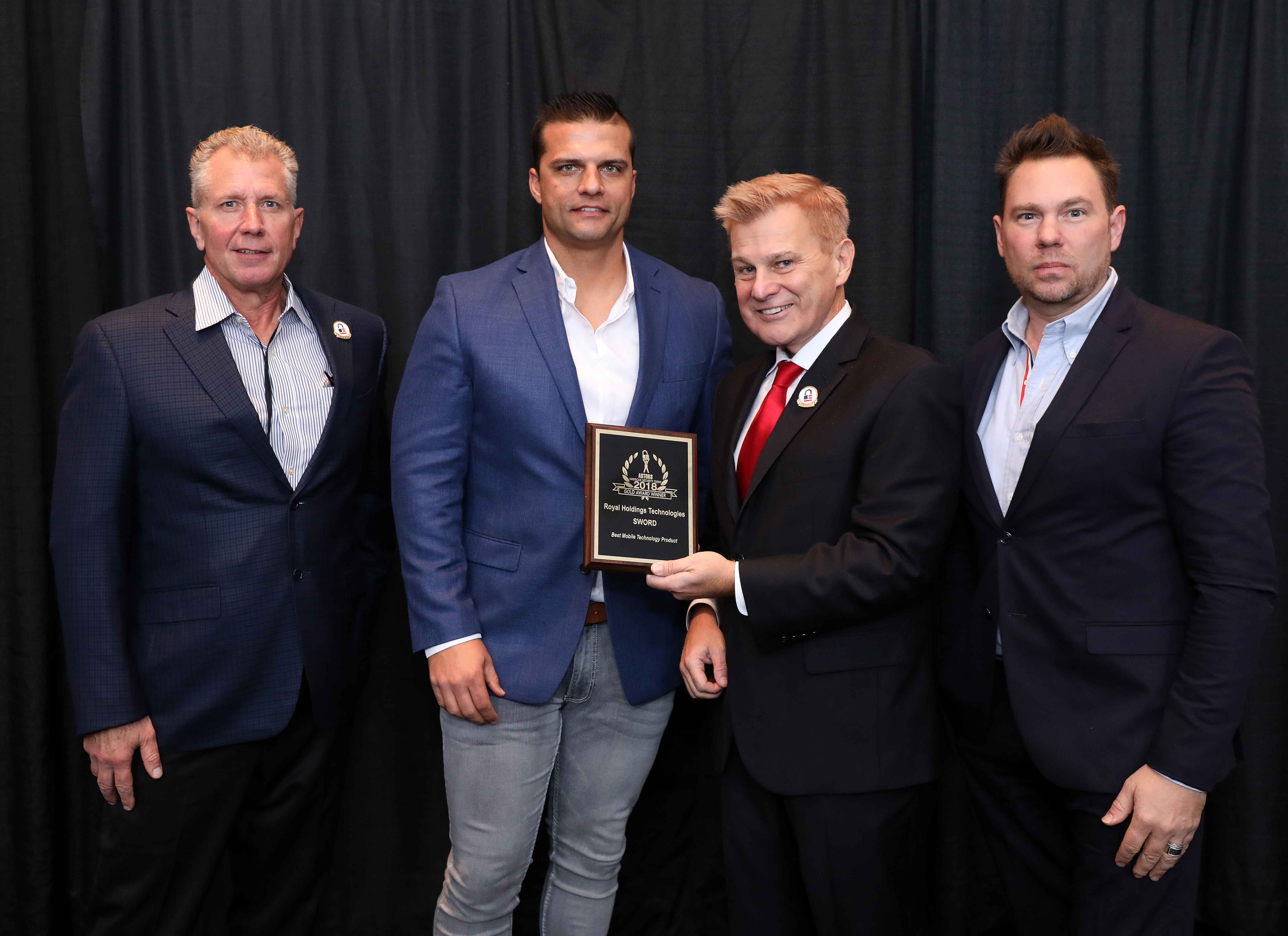 Chuck Bloomquist, Chief Technical Advisor, (left to right) Barry Oberholzer, Chief Executive Officer, and Jaromy Pittario, Chief Operating Officer of Royal Holdings Technologies accepting one of eight record-breaking 2018 ‘ASTORS’ Awards for the company’s SWORD Smartphone Security Scanning Devices.