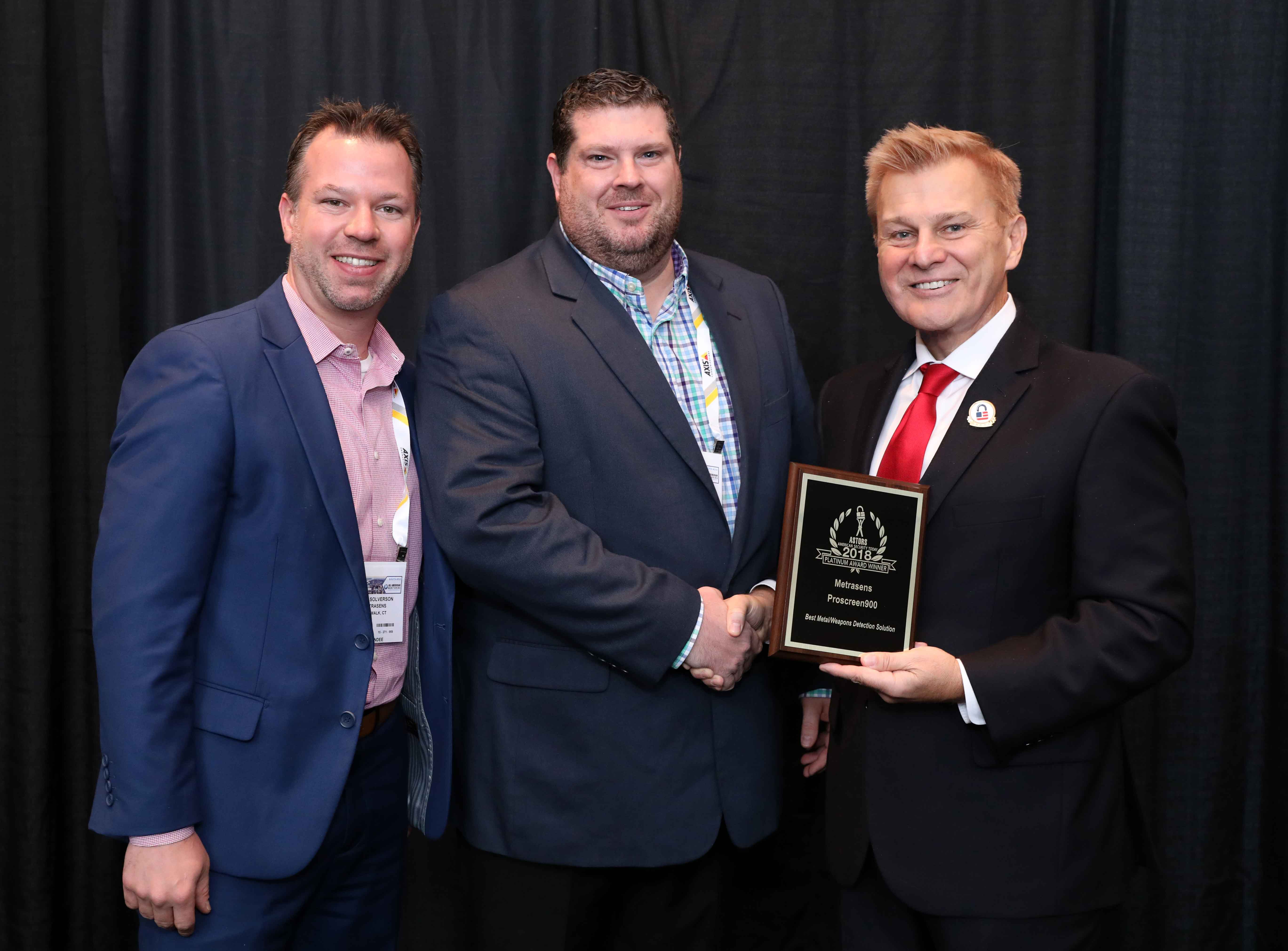 Dan Kuzniewski, Director of Marketing (center), with Brian Solverson, Key Acct Mgr, US High Security (at left), accepting the 2018 Platinum ‘ASTORS’ Homeland Security Award for Best Metal/Weapons Detection Solution at ISC East.
