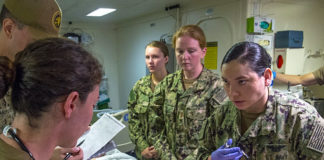 U.S. Sailors assigned to Fleet Surgical Team Three, led by Lt. j.g. Candice Carter (right) and Lt. Collen Casey (left), discuss the evaluation and care of a simulated patient in the Intensive Care Unit aboard the amphibious assault ship USS America (LHA 6) during a mass casualty drill. Sailors assigned to Fleet Surgical Team Three, USS America, USNS Mercy, and Naval Medical Center San Diego participated in the drill to increase operational readiness. (Courtesy of the U.S. Navy photo by Mass Communication Specialist First Class Sean P. Lenahan)