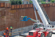 Crews work as United States Border Patrol Acting San Diego Sector Chief Kathleen Scudder delivers remarks applauding the completion of 14 miles of new border wall construction in San Ysidro, California, August 9, 2019. (Courtesy of CBP, by Tim Tucciarone)