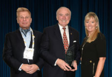 Mike Madsen, AST Publisher (at left); and Tammy Waitt, Managing Director (at right); presenting Commissioner William J. Bratton with his 2019 'ASTORS' Person of the Year Award at the 'ASTORS' Awards Luncheon at ISC East.
