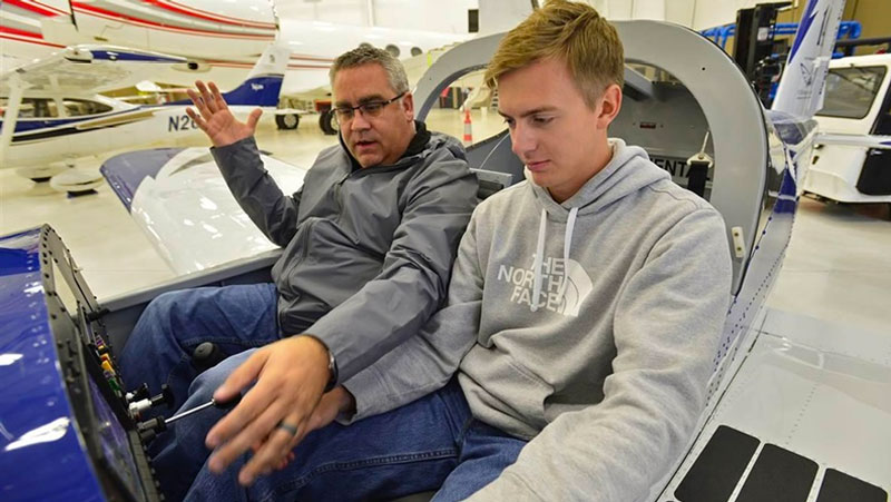 Phillip Campbell familiarizes a Van's Aircraft RV-12 cockpit with McKinney High School student Bryan Soltys-Niemann during an aviation class at McKinney National Airport in McKinney, Texas, Nov. 8. (Courtesy of Facebook AOPA, and David Tulis.)