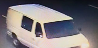 The vehicle is a white van identified as a 1997-2002 Ford E-250 or E-350 Cargo Van. The occupants of the van should be considered armed and dangerous. Please call 911 immediately and do not approach the van.