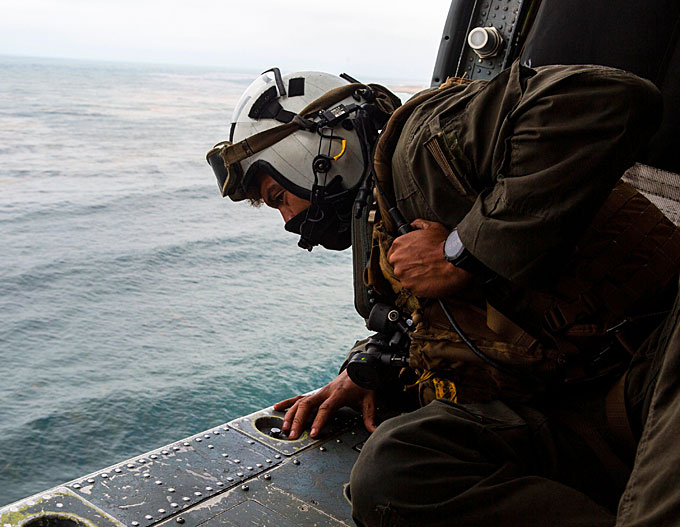 Naval Air Crewman 2nd Class Joseph Rivera, a search and rescue swimmer looking out of a US Navy MH-60 Seahawk, helped conduct the search and rescue relief operations. (Courtesy of 15th MEU by Lance Cpl. Mackenzie Binion and Twitter)