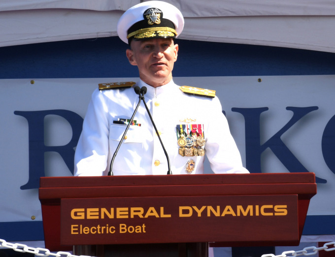 Adm. James Caldwell, Jr., delivers remarks in front of the pre-commissioning unit (PCU) Hyman G. Rickover (SSN 795) during a christening ceremony at General Dynamics Electric Boat shipyard facility. Rickover and crew will operate under Submarine Squadron (SUBRON) FOUR whose primary mission is to provide attack submarines that are ready, willing, and able to meet the unique challenges of undersea combat and deployed operations in unforgiving environments across the globe. (Courtesy of the U.S. Navy by Chief Petty Officer Joshua Karsten)