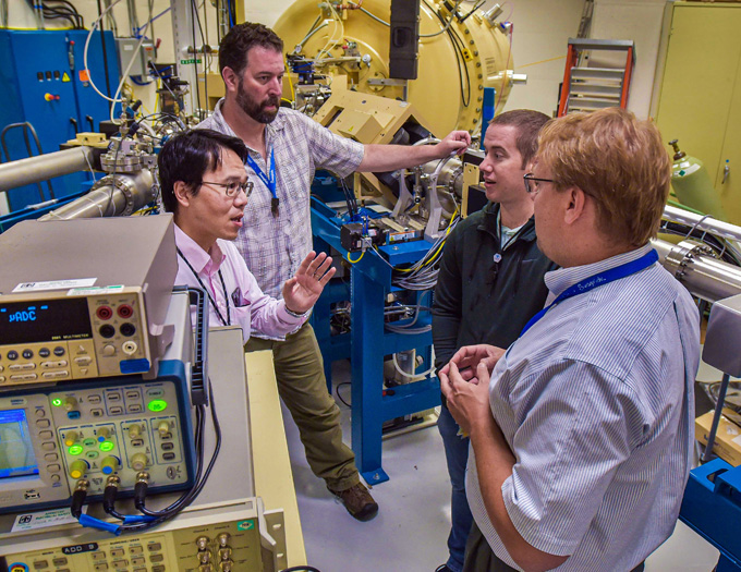 Sandia National Laboratories researchers, from left, Yuan-Yu Jau, George Burns, Justin Christensen and Ed Bielejec plan to test a future neutron generator for an electric-field imaging system at Sandia’s Ion Beam Laboratory, pictured here. (Courtesy of Sandia Labs by Randy Montoya)