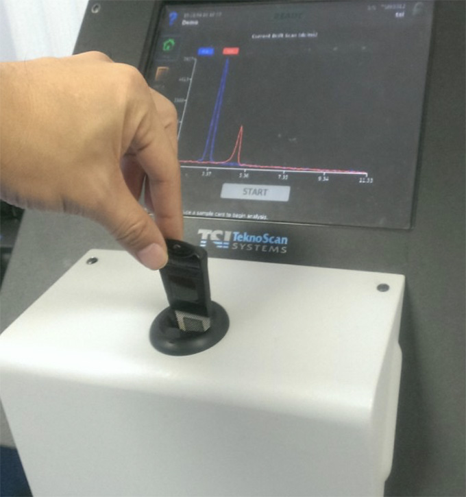 Figure 3: Sample card inserted into detector for analysis. The same concept is used in non-invasive screening of marine containers for hidden drugs and explosives. (Courtesy of Teknoscan)
