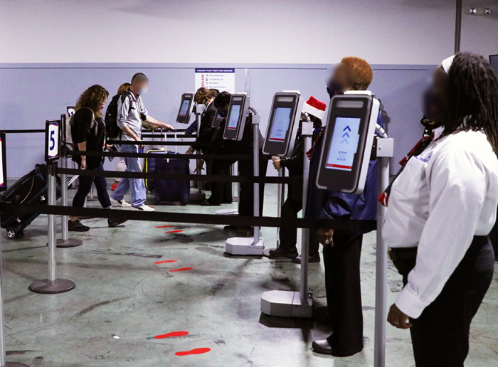 Debarking passengers walk up to new technology that will match their identity to their travel document photo  within two seconds, while Carnival Cruise Line employees assist. (Courtesy of CBP)