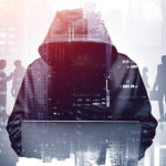 Unrecognizable,Young,Hacker,In,Hoodie,Using,Laptop,In,Blurry,City.