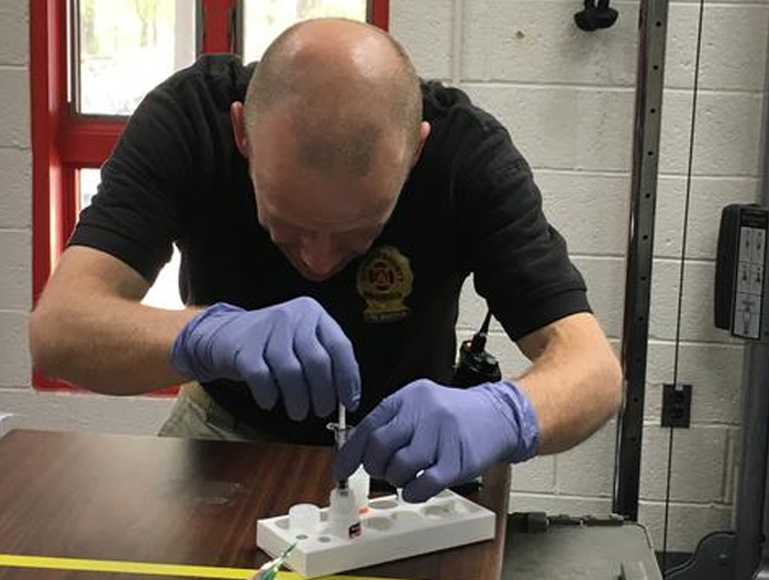 NIST researchers conducted interlaboratory studies with first responders and public health laboratories. In this field study, Jeremy Clancy, Battalion Chief of the Howard County Department of Fire Rescue Services, samples the yeast material in a powdered form using the existing field protocols. (Courtesy of NIST by N. Lin)